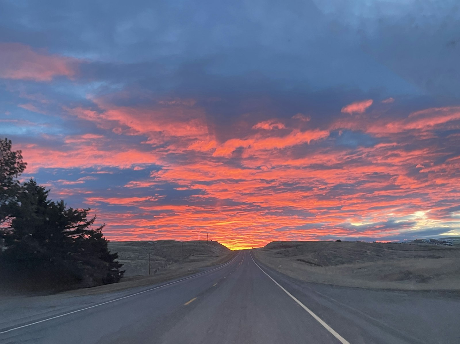 A road stretching toward a bright horizon at sunrise